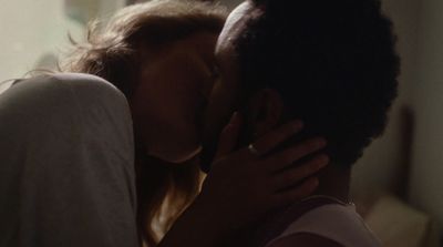 a man and a woman kissing in a room