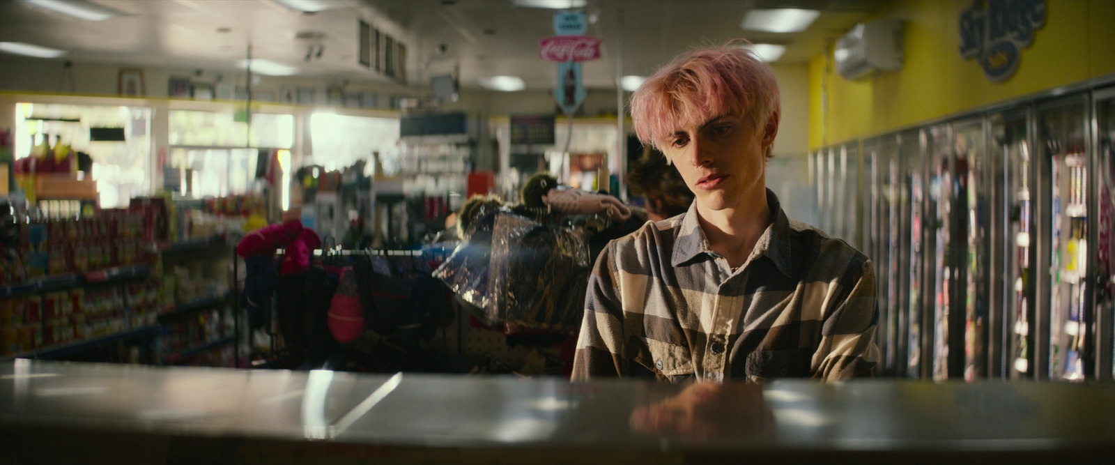 a man with pink hair standing in a store