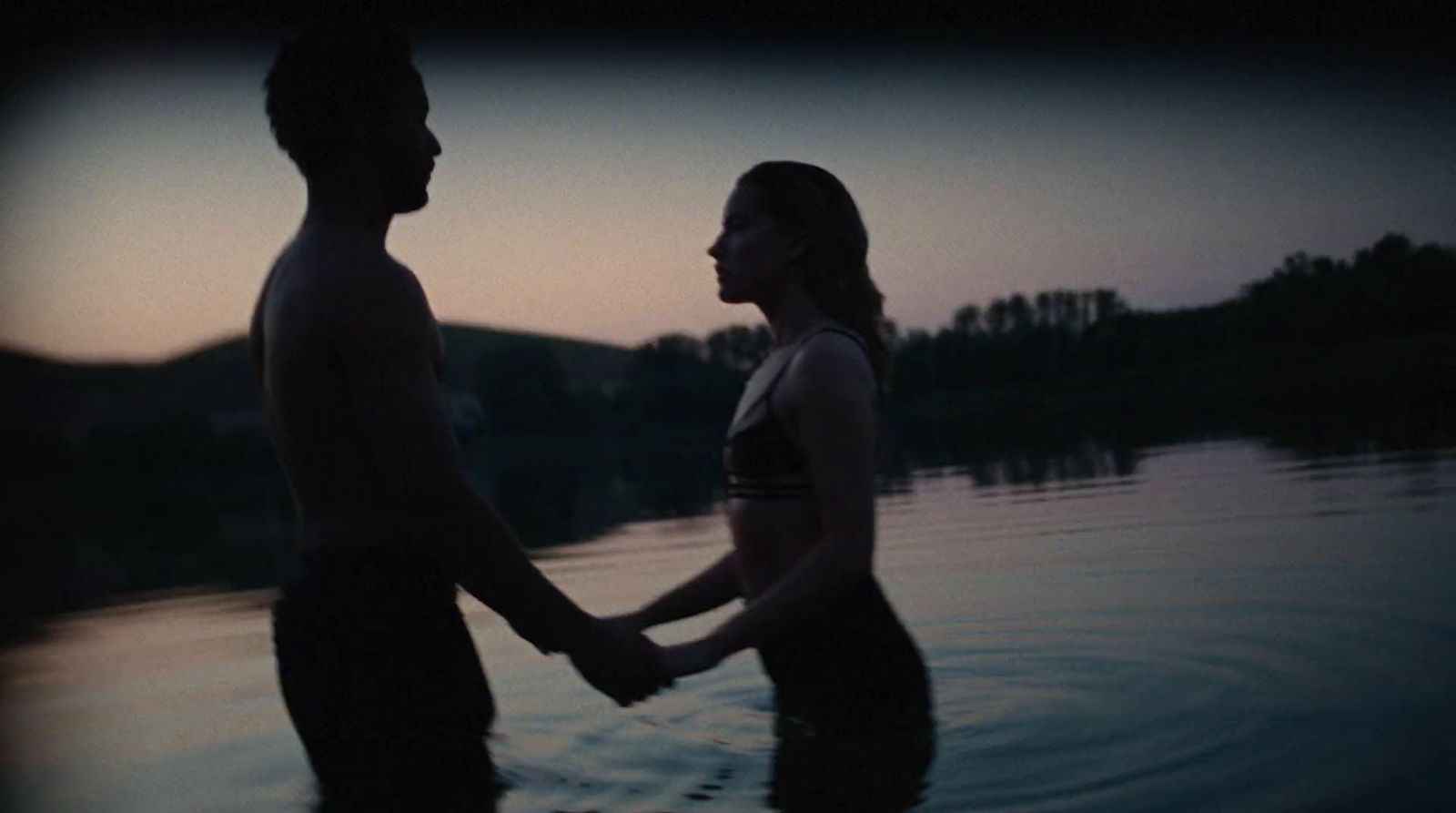 a man and a woman holding hands in the water