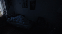 a dark room with a bed and a window