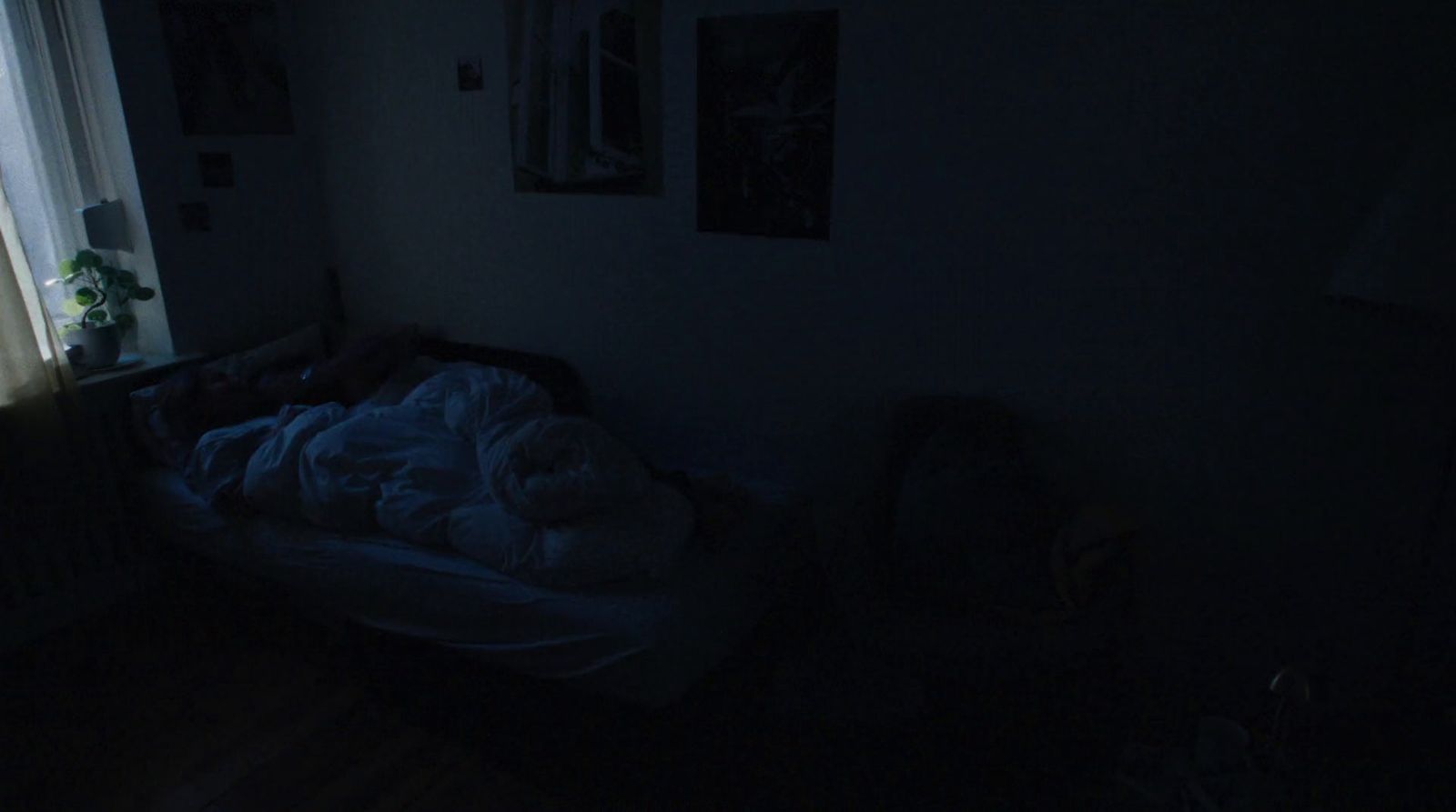 a dark room with a bed and a window