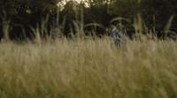 two people in a field of tall grass