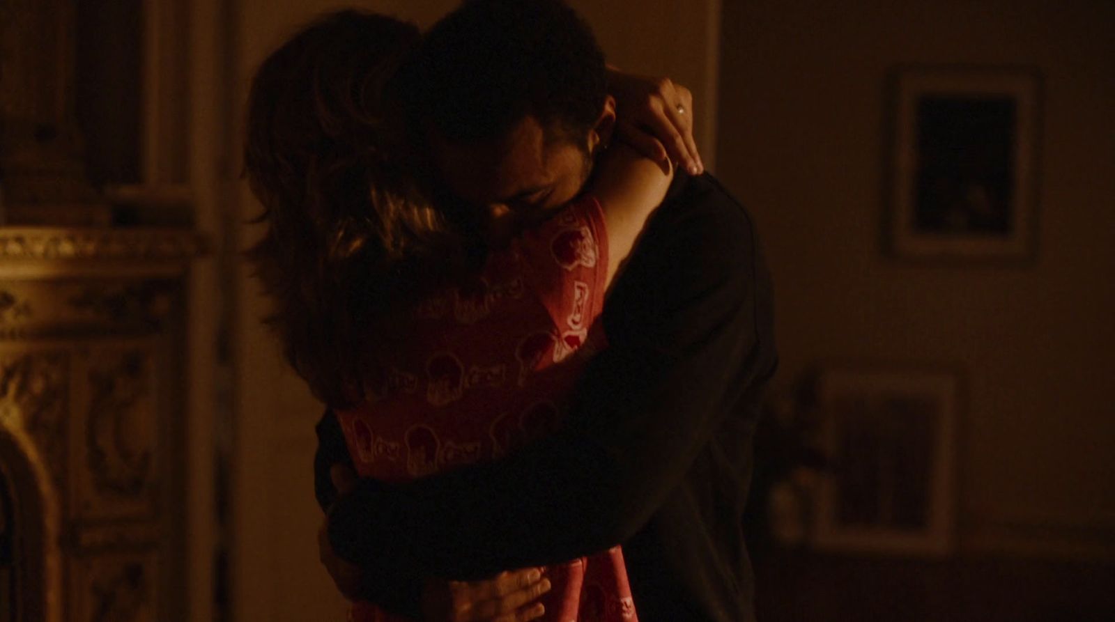 a man and a woman embracing in a dimly lit room