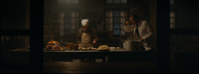 two chefs preparing food in a dark kitchen