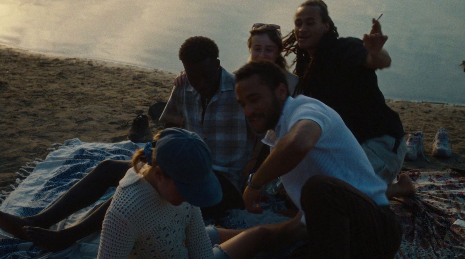 a group of people sitting on top of a blanket