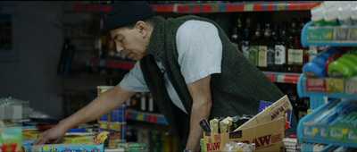 a man in a grocery store picking up a box