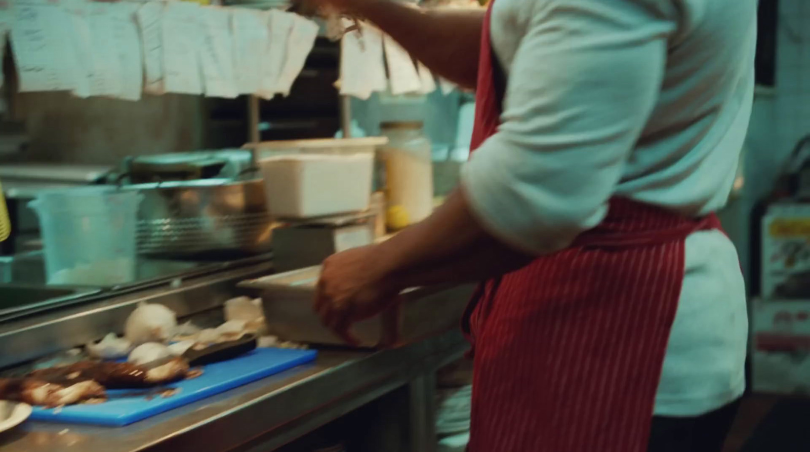 a person in a kitchen preparing food on a cutting board