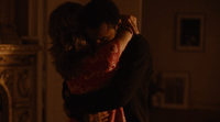 a man and a woman hug in a dimly lit room