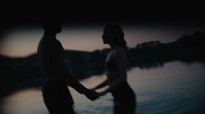 a man and a woman standing in the water holding hands