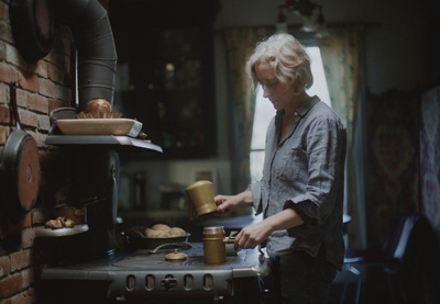 a woman standing in a kitchen preparing food