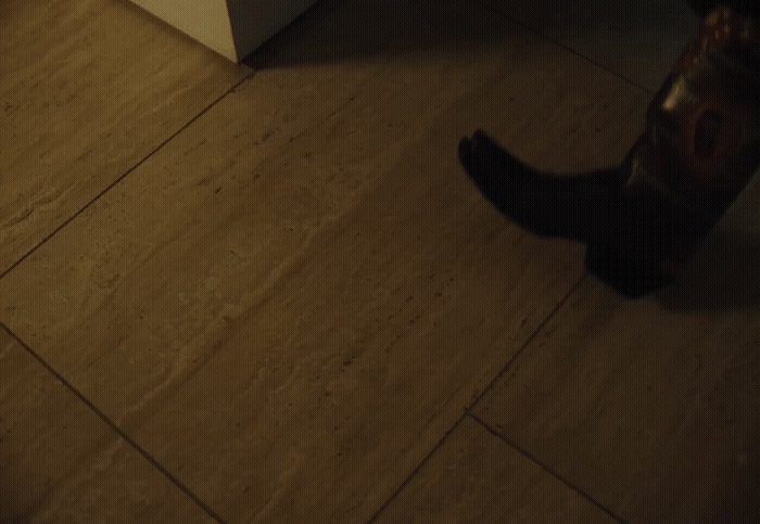 a person standing on a tile floor next to a refrigerator