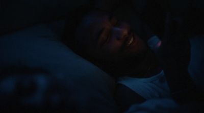 a man laying in bed in the dark