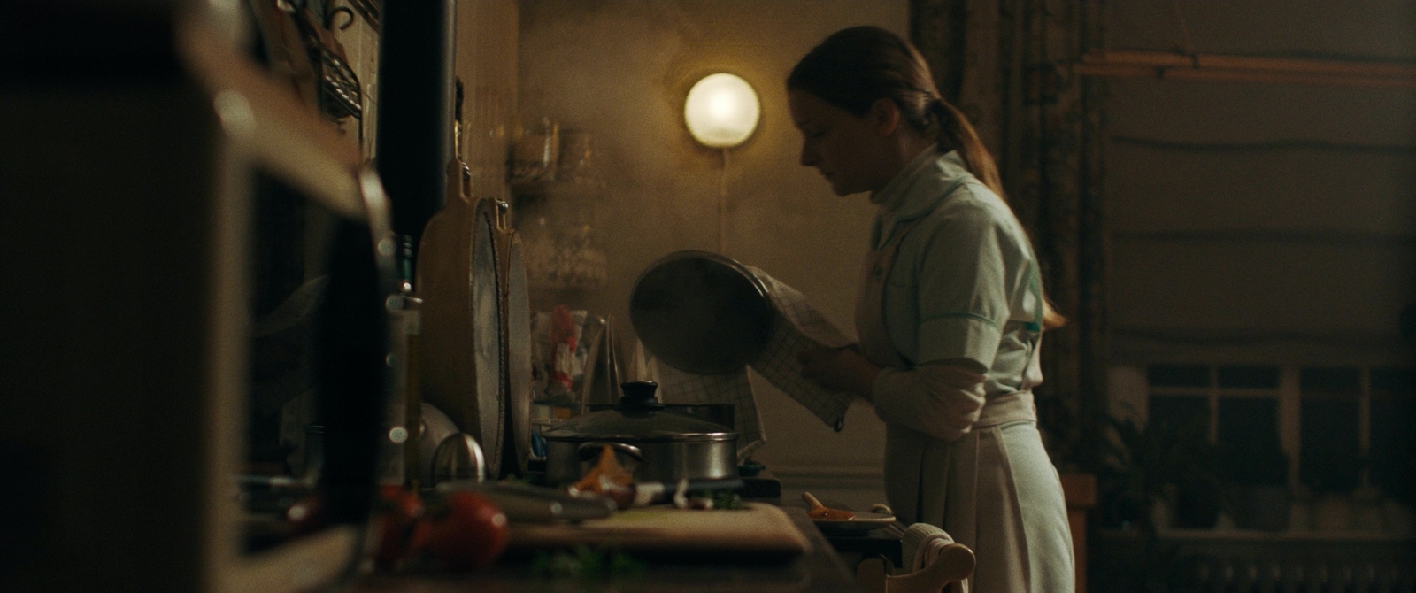 a woman standing in a kitchen preparing food