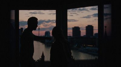 a man and a woman standing in front of a window