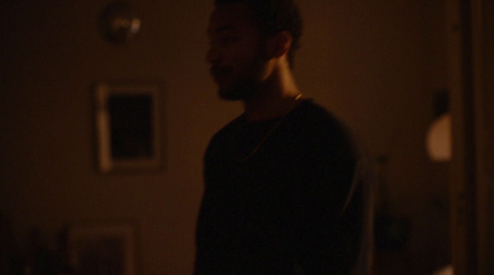 a man standing in a dark room with a light on