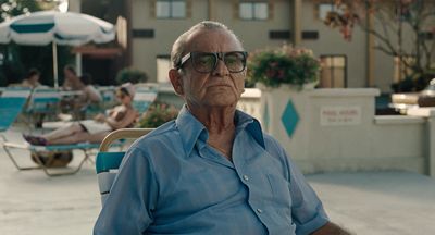 a man sitting in a chair next to a swimming pool