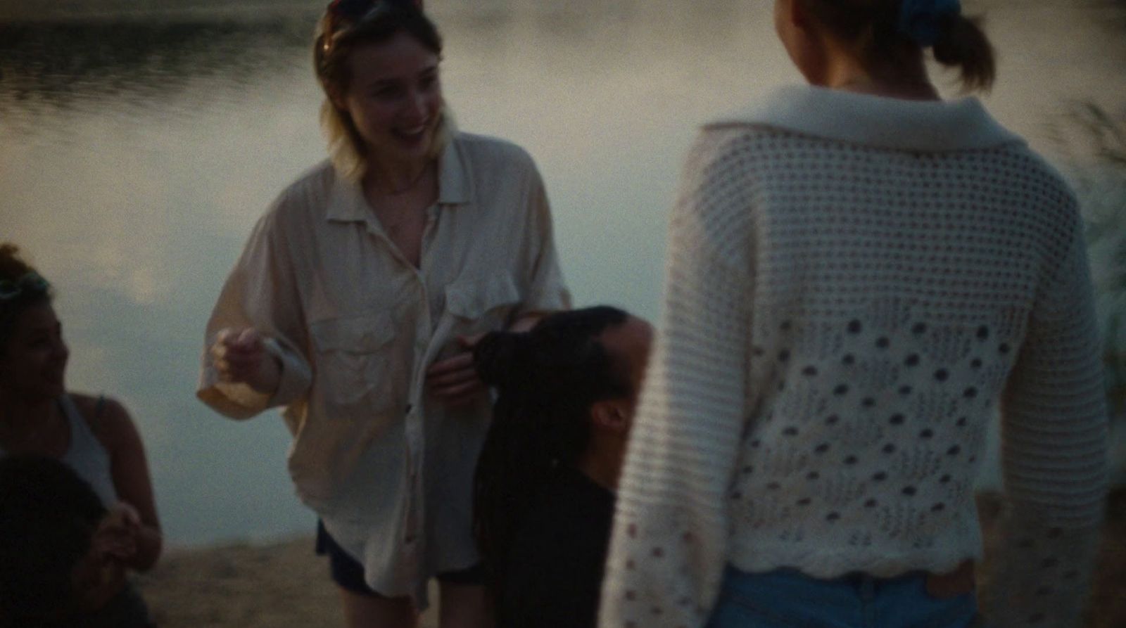 a group of women standing next to each other near a body of water