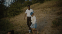 a man and a woman walking up a hill