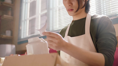 a woman in an apron is opening a box