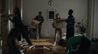 a group of people unpacking boxes in a living room