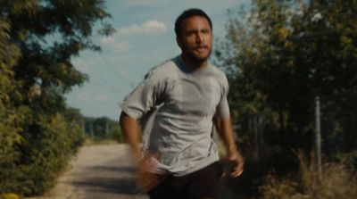 a man riding a skateboard down a dirt road