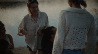 a group of women standing next to a body of water