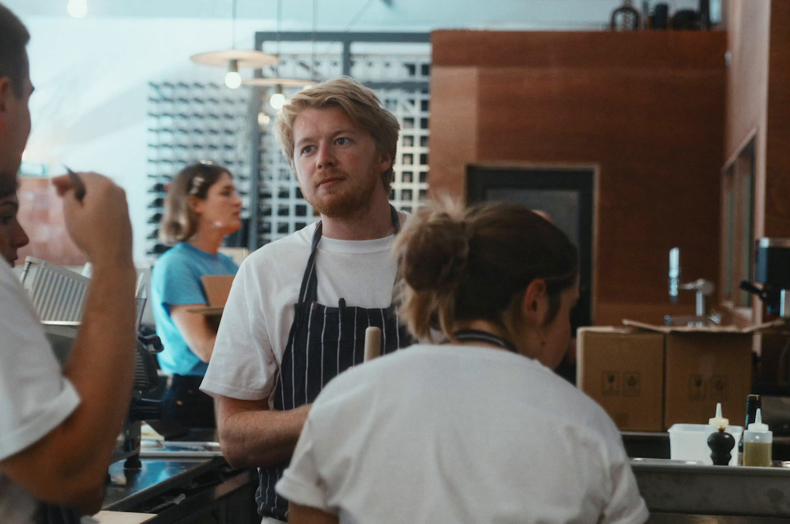 a group of people standing around a kitchen