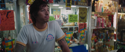 a man standing in front of a store filled with posters