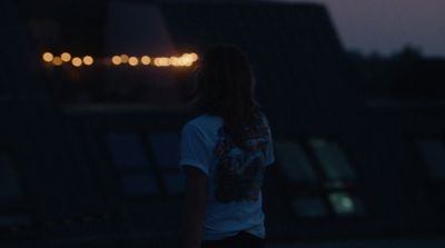 a person standing in the dark with their back to the camera