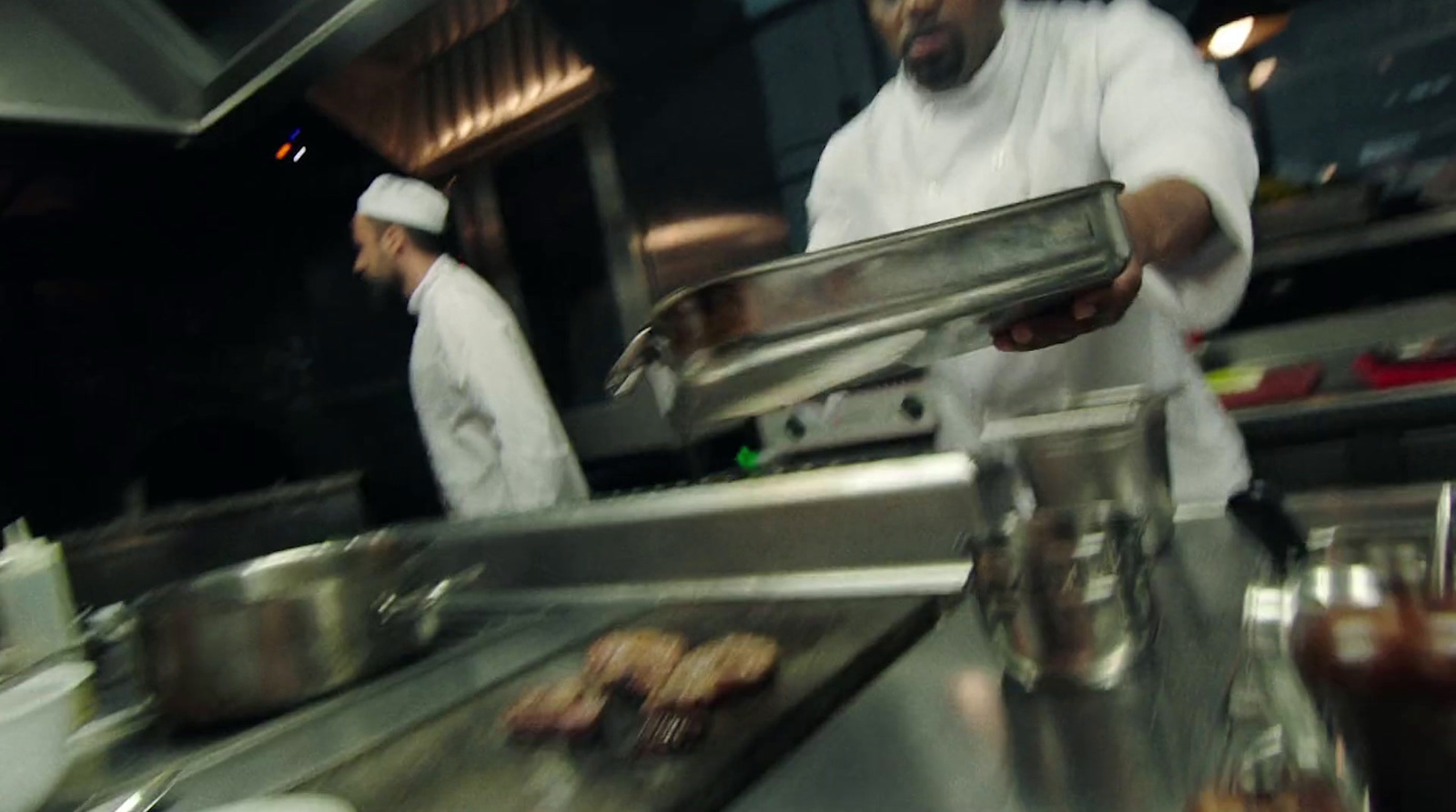 two chefs are preparing food in a kitchen