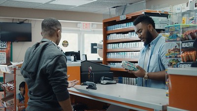 a couple of men standing at a cash register