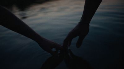 a person holding the hand of another person in the water