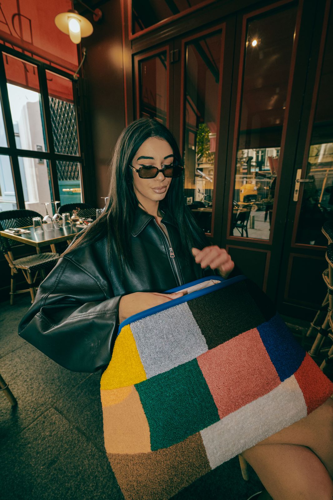 a woman in a black leather jacket and sunglasses
