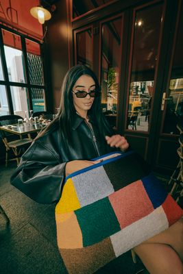 a woman in a black leather jacket and sunglasses