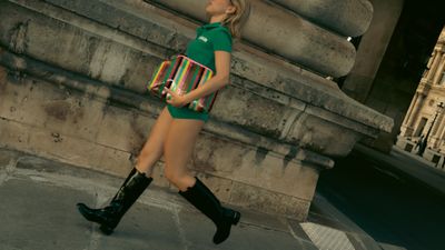 a woman in a green dress is walking down the street