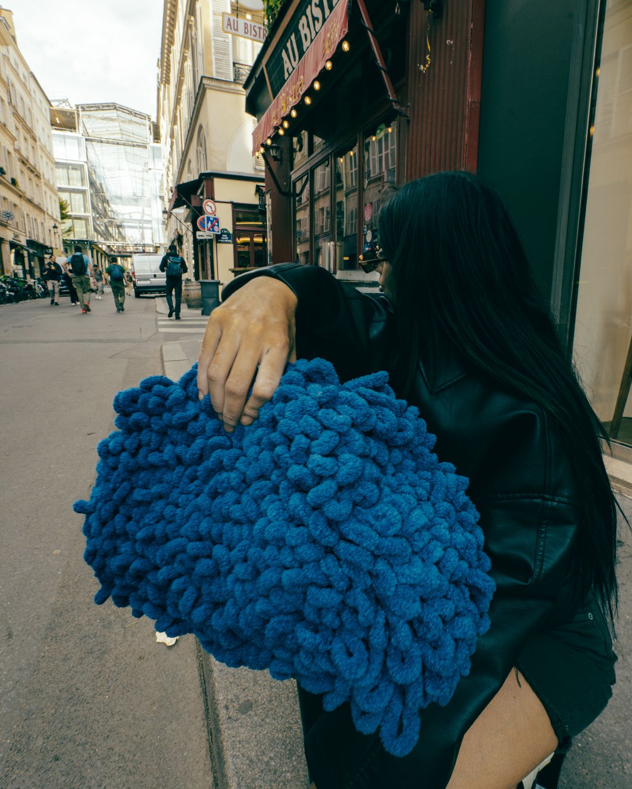 a woman is holding a blue blanket on the street