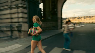 a woman in a short green dress is crossing the street