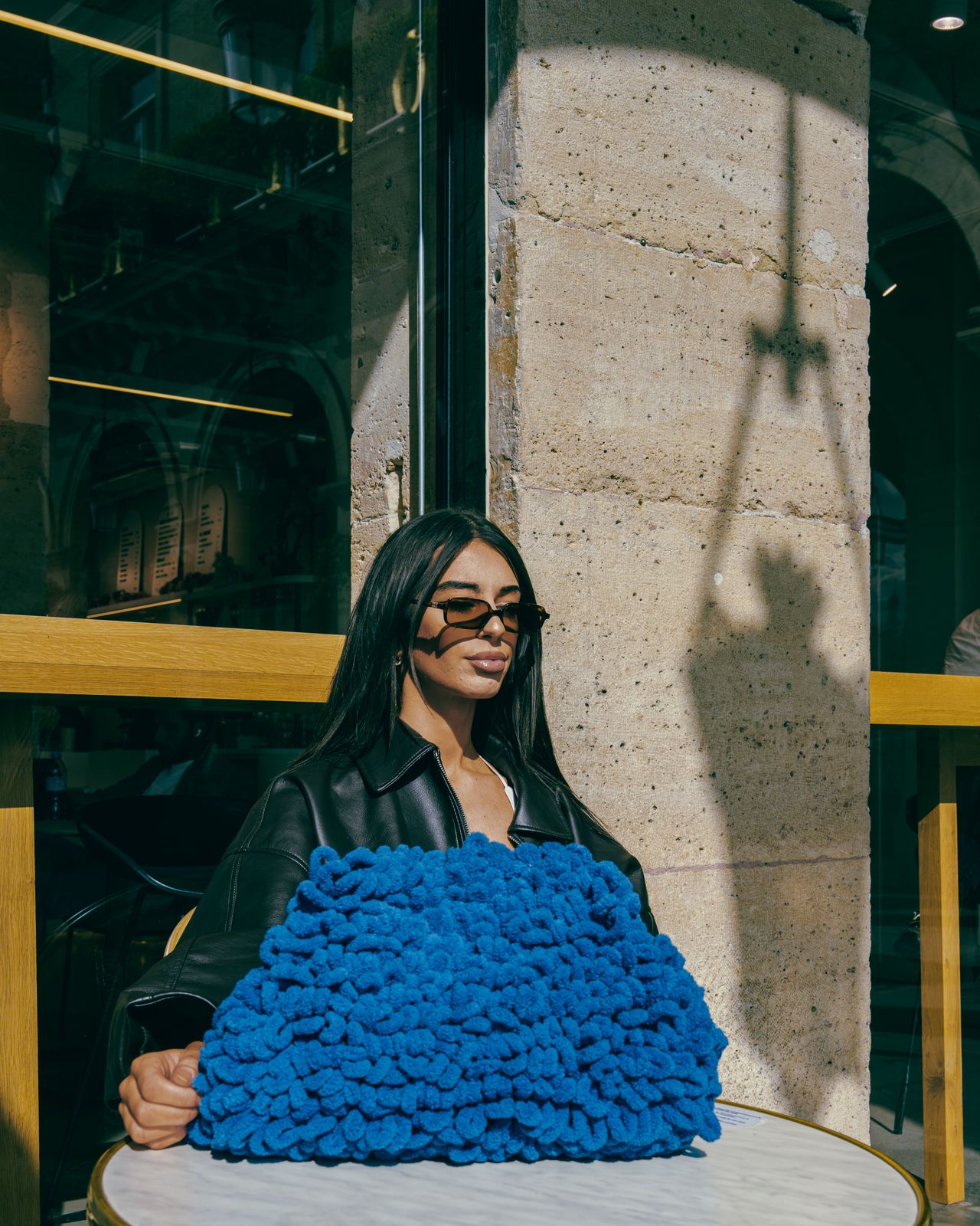 a woman sitting at a table with a blue blanket on it