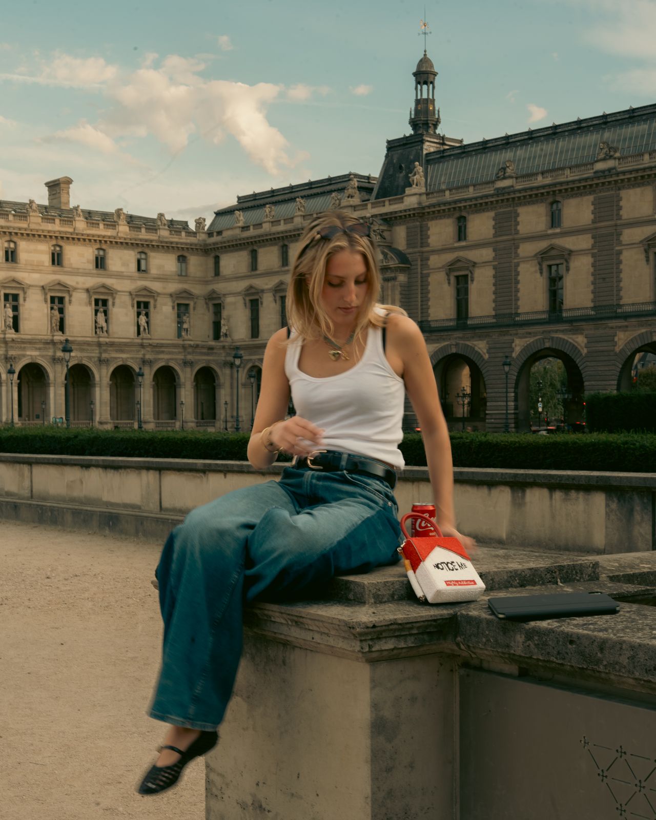 a woman sitting on a ledge in front of a building