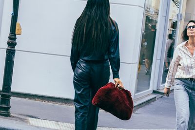 a woman walking down a street next to another woman