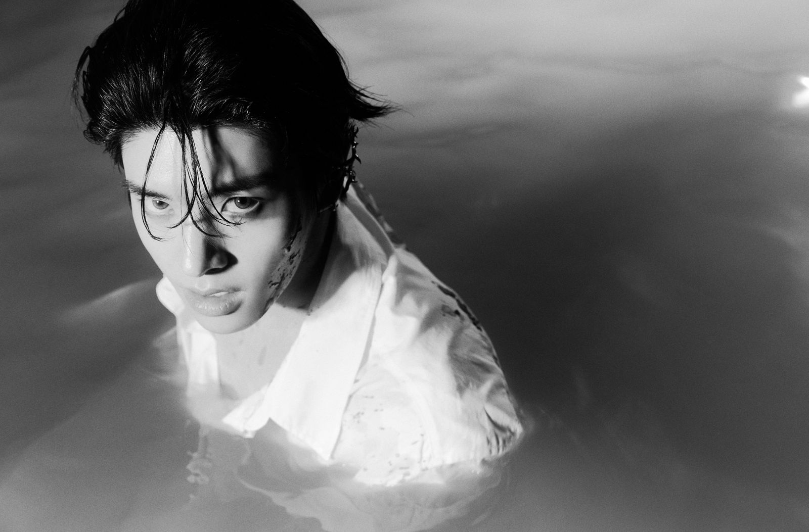 a black and white photo of a man in water