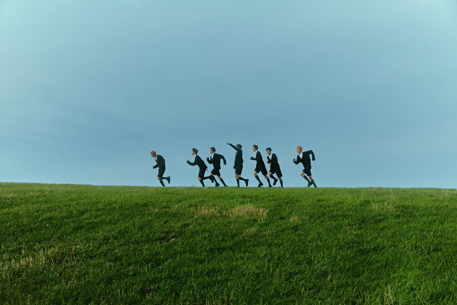 a group of people running across a lush green field