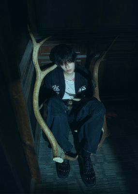 a person sitting in a chair with a fake tree branch