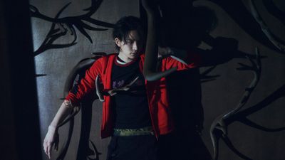 a person standing in front of a wall with a snake on it