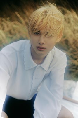 a young man in a white shirt and black skirt