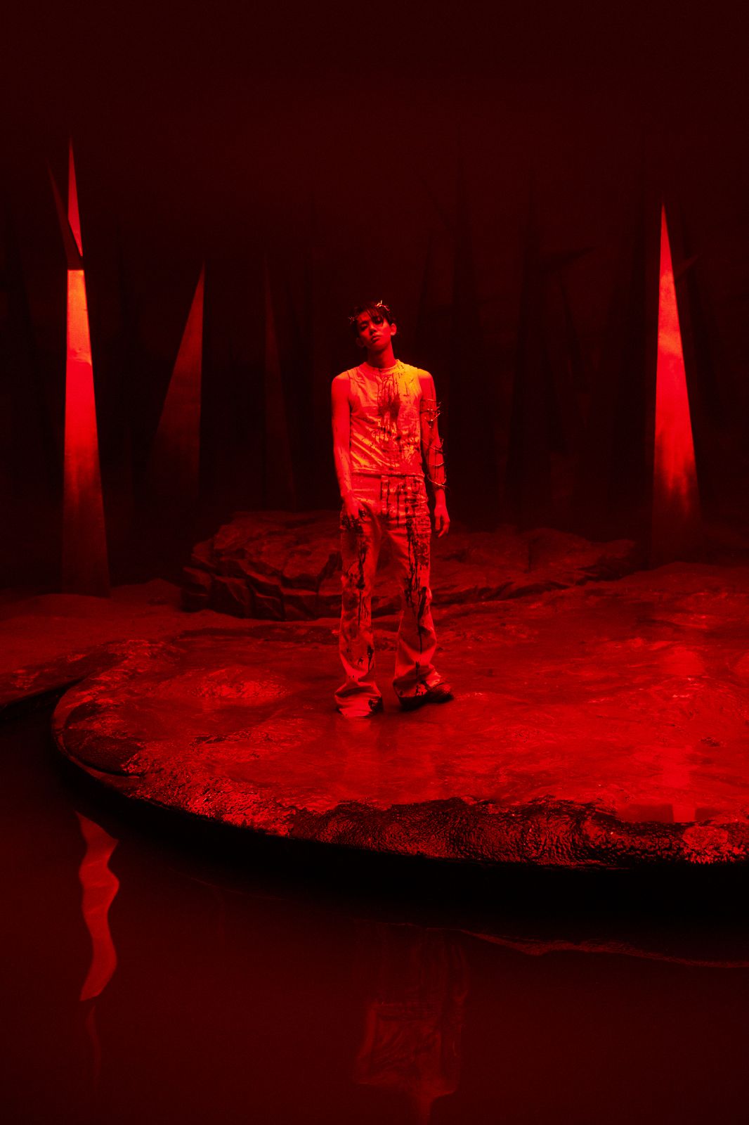 a man standing on a stage with red lights