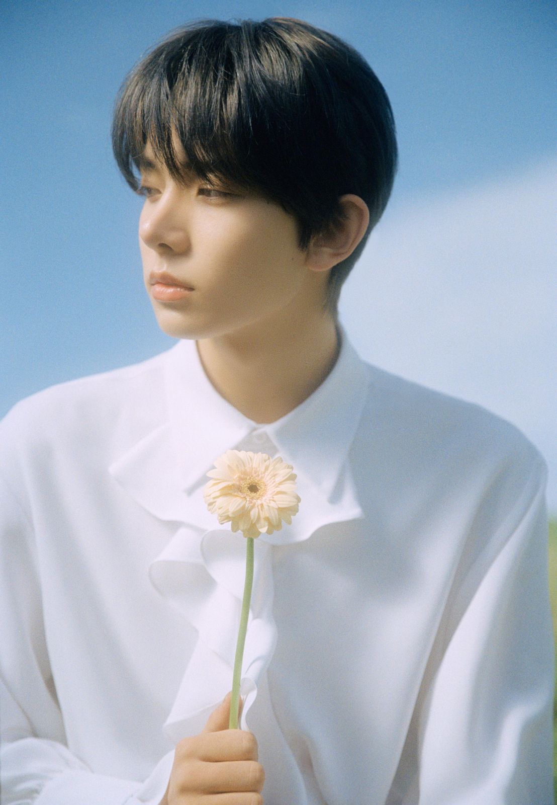 a man in a white shirt holding a flower