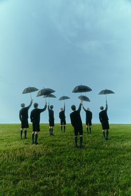 a group of people standing on top of a lush green field