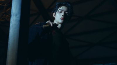 a young man holding a baseball bat in the dark