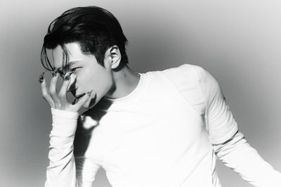 a man in a white shirt smoking a cigarette